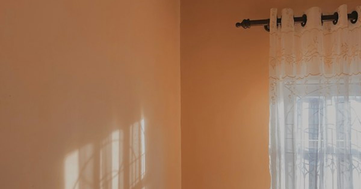 Open residential window with sheer lace curtain catching natural outdoor airflow and fresh breeze