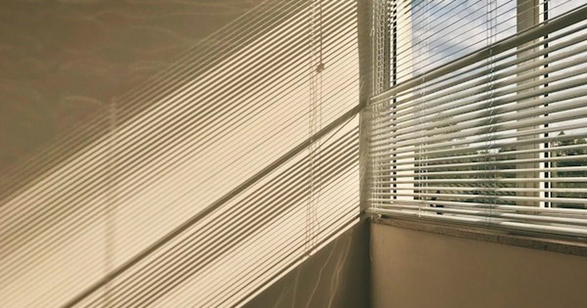 Thermal window blinds and slatted shades catching warm winter sunlight and casting protective thermal shadows
