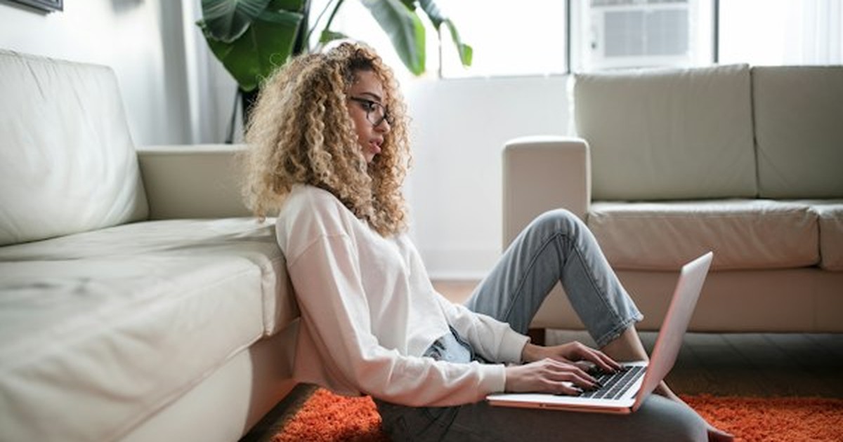 Individual slouched forward over a laptop demonstrating poor spinal alignment and neck strain