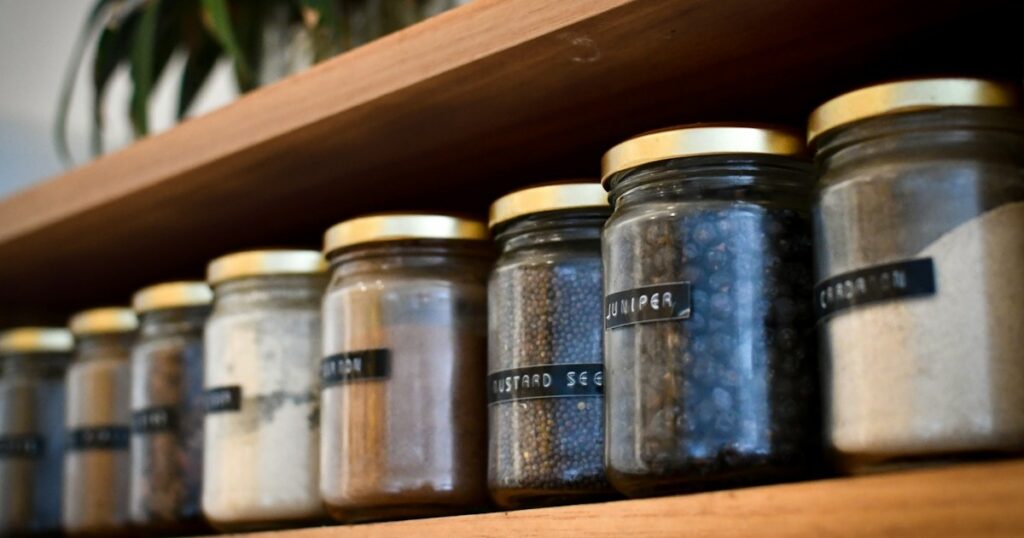 Zero-Waste Kitchen Habits: 8 Realistic Swaps That Cut Waste in Half a shelf filled with lots of different types of spices